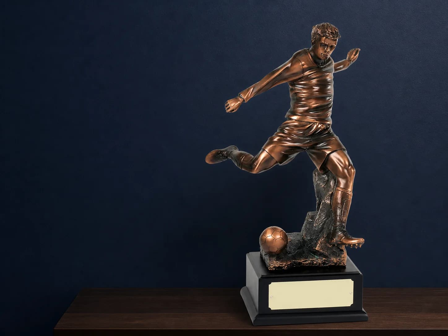 Bronze football trophy on a black presentation base