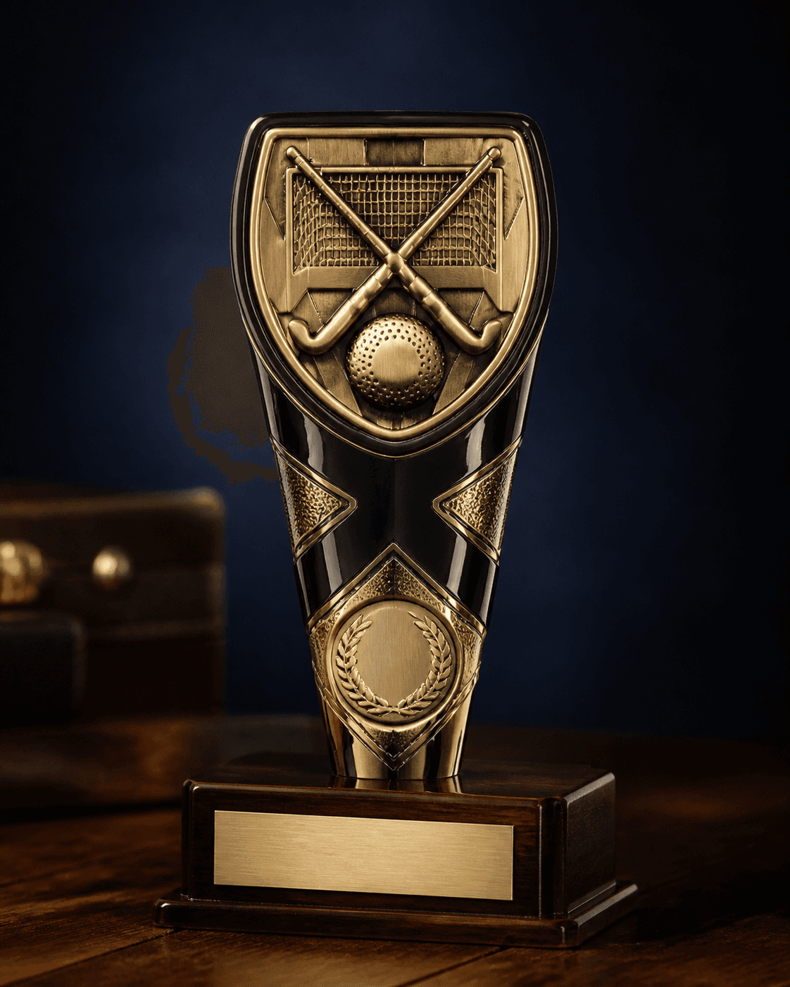 Black and gold field hockey shield award on a mahogany plinth