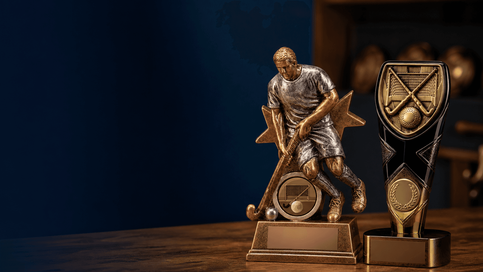 Field hockey trophies displayed on a walnut table in a heritage workshop