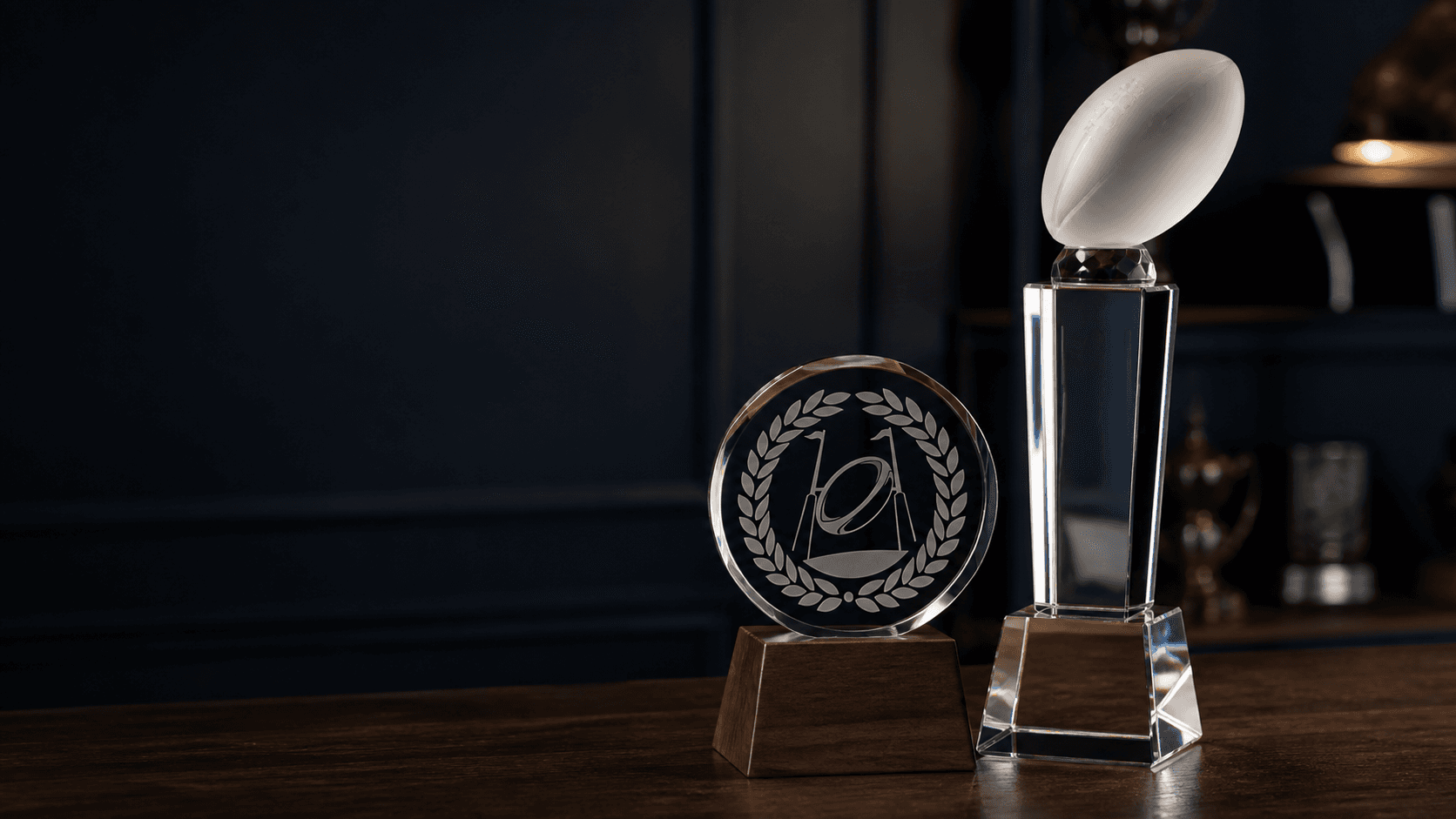 Crystal rugby trophies displayed on a walnut table in a heritage workshop
